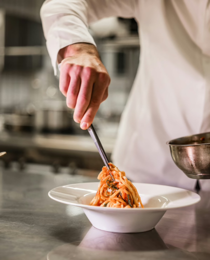 eine Person, die eine Gabel über einer Schüssel mit Nudeln hält